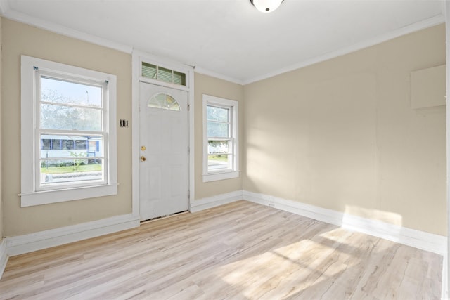 foyer entrance with light hardwood / wood-style floors, plenty of natural light, and crown molding