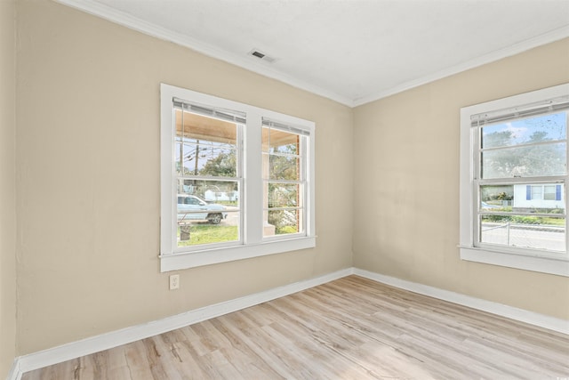 spare room with light wood-type flooring and ornamental molding