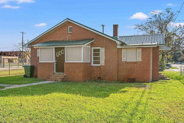 rear view of house featuring a yard