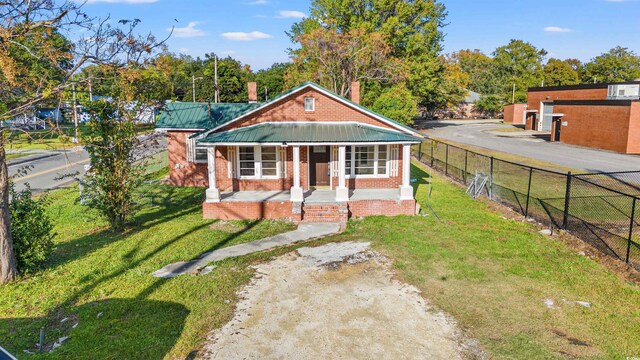 bungalow-style home with covered porch and a front yard