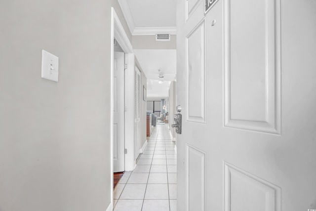 hallway with light tile patterned floors and crown molding