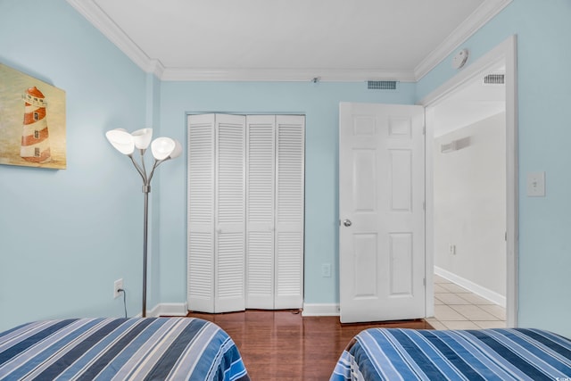 bedroom featuring dark hardwood / wood-style flooring, a closet, and crown molding