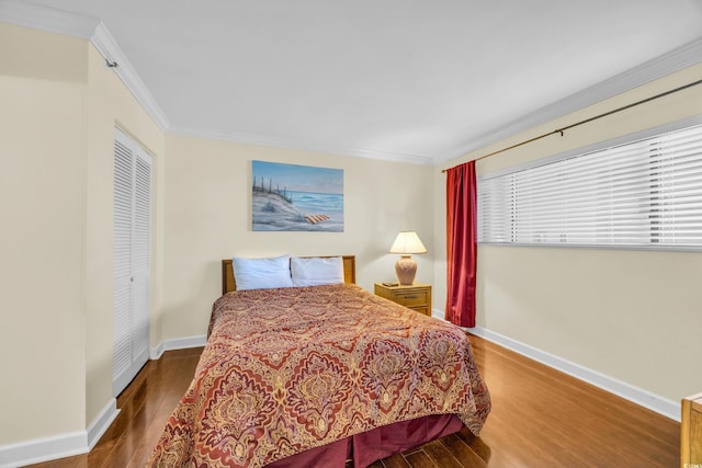 bedroom featuring a closet, hardwood / wood-style floors, and crown molding