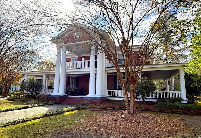 greek revival inspired property with a porch and a balcony