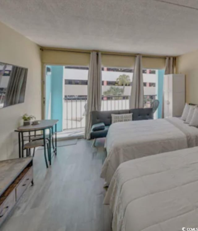 bedroom with light wood-type flooring and a textured ceiling