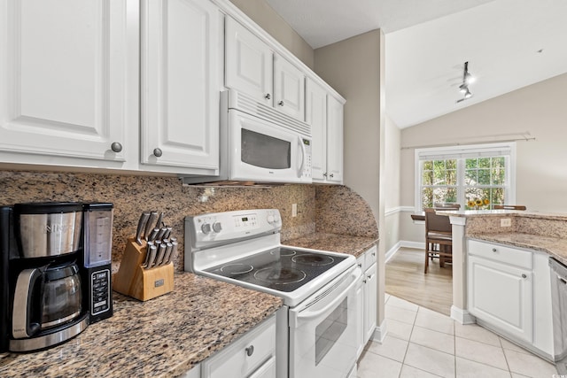 kitchen featuring white appliances, tasteful backsplash, light tile patterned floors, white cabinets, and vaulted ceiling