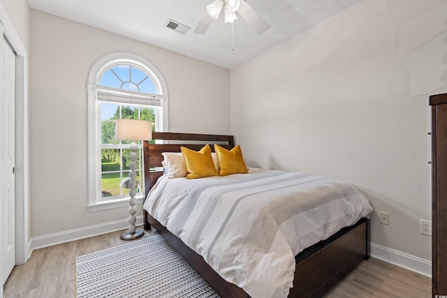 bedroom with multiple windows, visible vents, and wood finished floors