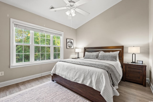 bedroom featuring lofted ceiling, wood finished floors, a ceiling fan, and baseboards