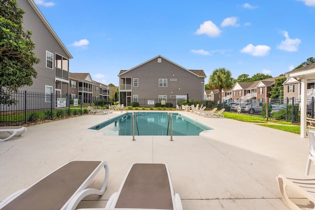 pool featuring a patio, fence, and a residential view