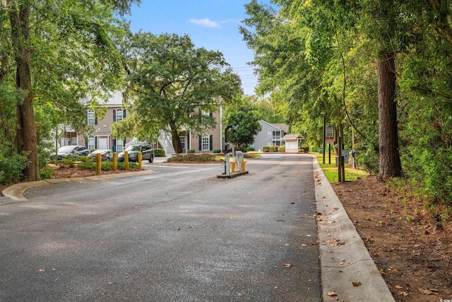 view of street with traffic signs, a residential view, and curbs