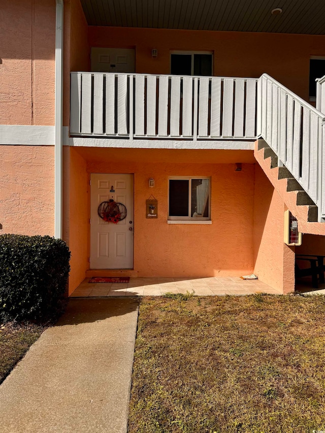 view of exterior entry with a balcony