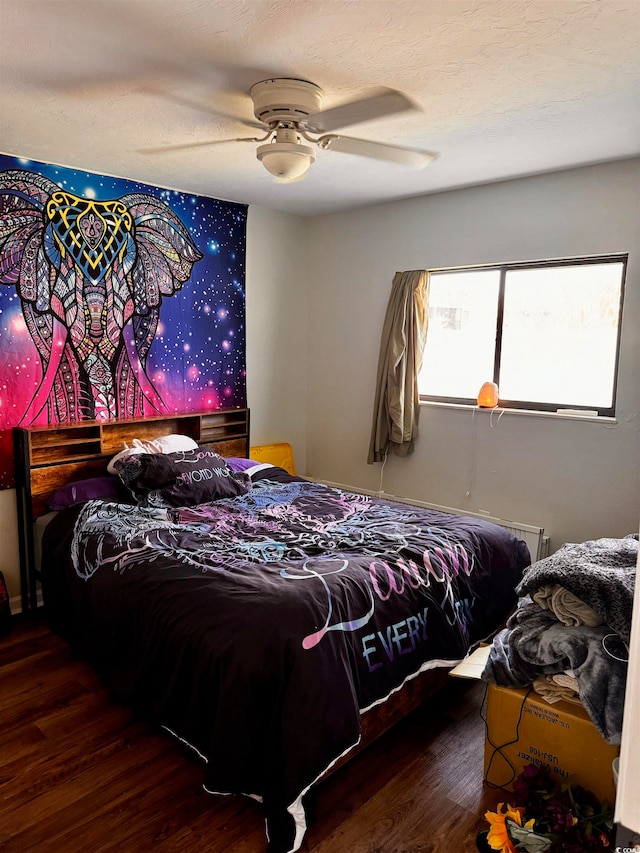 bedroom with a textured ceiling, dark wood-type flooring, and ceiling fan