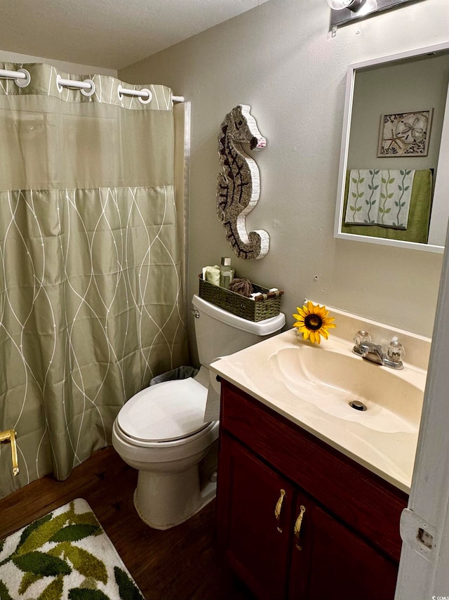 bathroom featuring toilet, hardwood / wood-style floors, curtained shower, a textured ceiling, and vanity