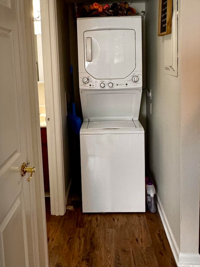 clothes washing area featuring dark hardwood / wood-style flooring, electric panel, and stacked washer and dryer