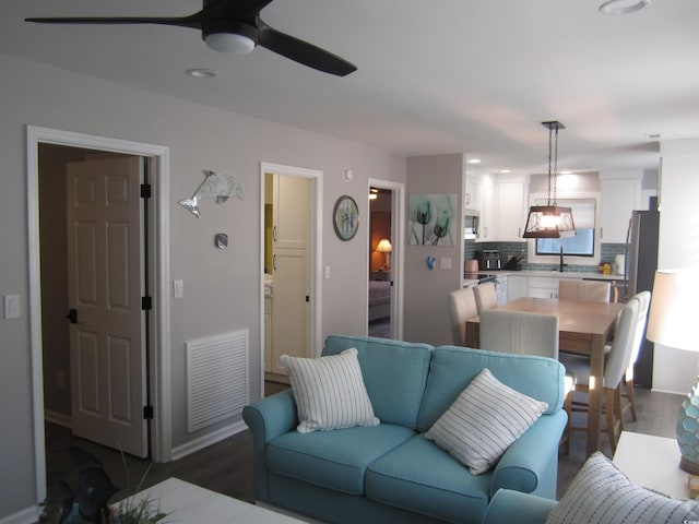 living room with ceiling fan, sink, and dark hardwood / wood-style flooring