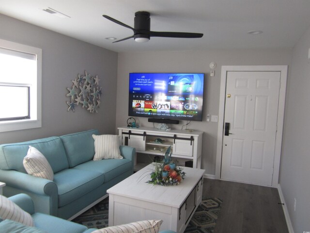 living room with dark hardwood / wood-style flooring and ceiling fan