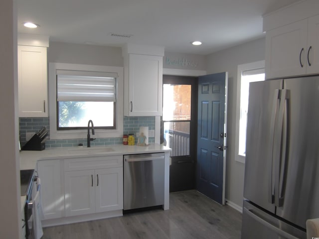 kitchen with light hardwood / wood-style flooring, white cabinets, sink, and stainless steel appliances