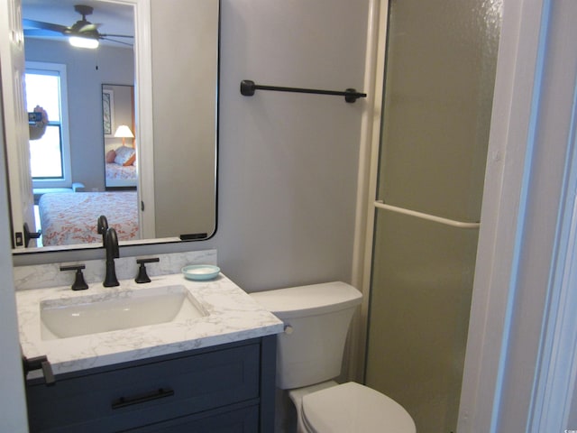 bathroom with toilet, vanity, and ceiling fan