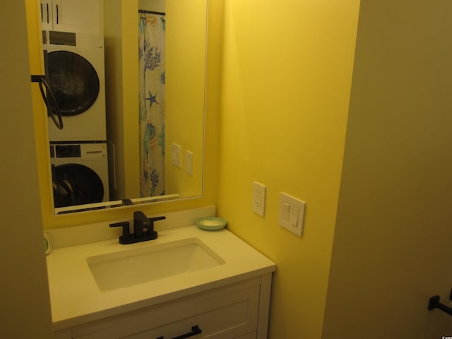 bathroom with stacked washing maching and dryer and vanity