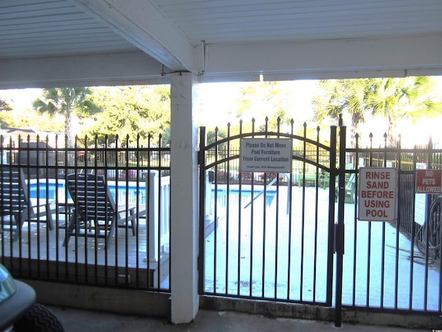 view of gate featuring a community pool