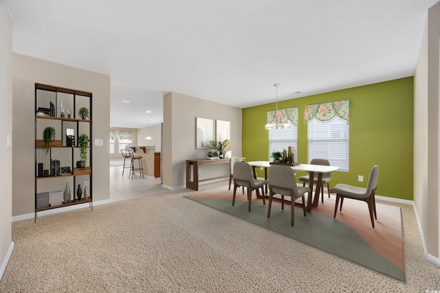 dining area featuring an inviting chandelier and light carpet