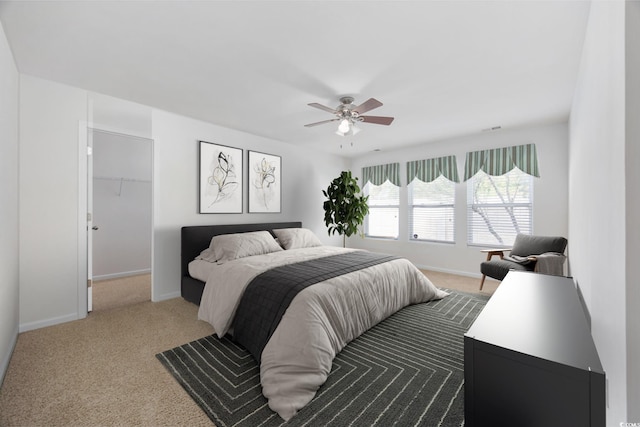 bedroom with ceiling fan, a spacious closet, carpet floors, and a closet