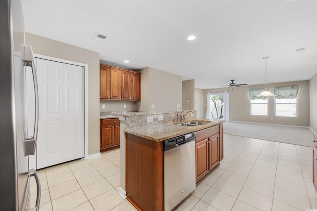 kitchen with sink, an island with sink, pendant lighting, light colored carpet, and stainless steel appliances