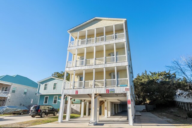 coastal inspired home featuring a balcony and a carport