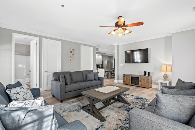 living room with light wood-type flooring and ornamental molding