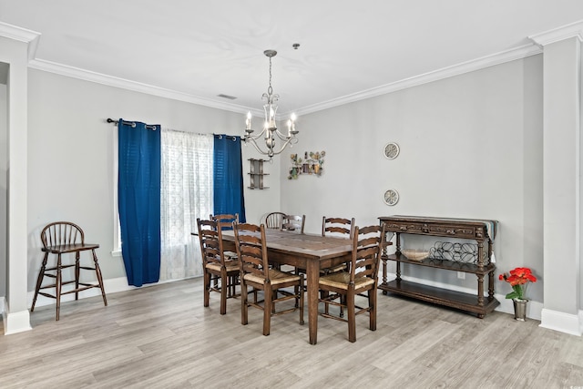 dining room with a chandelier, light wood-type flooring, visible vents, and crown molding