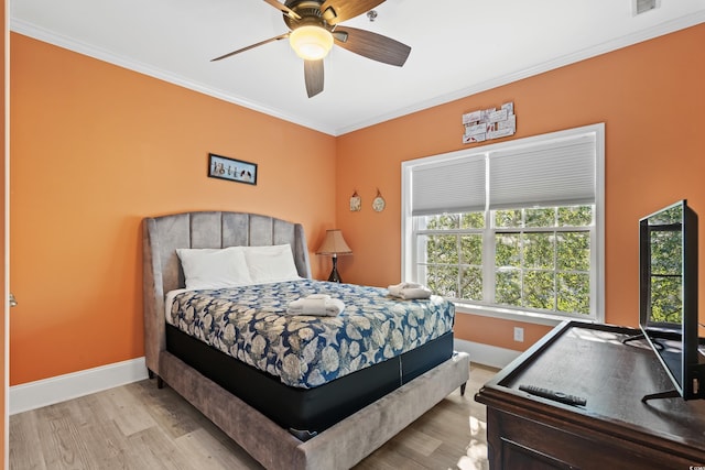 bedroom featuring ornamental molding, ceiling fan, baseboards, and wood finished floors