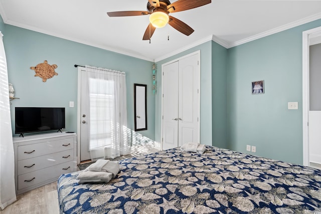 bedroom featuring ceiling fan, a closet, crown molding, and wood finished floors