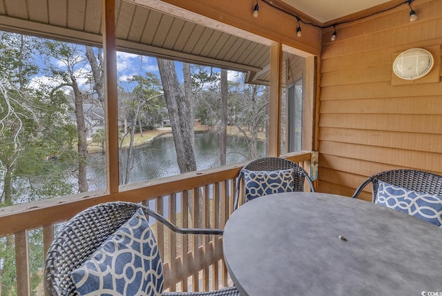 sunroom / solarium featuring a water view