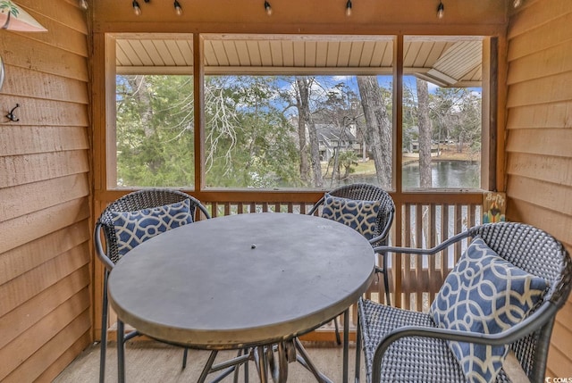 sunroom / solarium featuring a water view