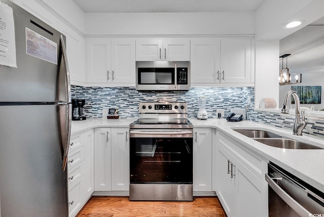 kitchen with white cabinetry, sink, stainless steel appliances, and light wood-type flooring