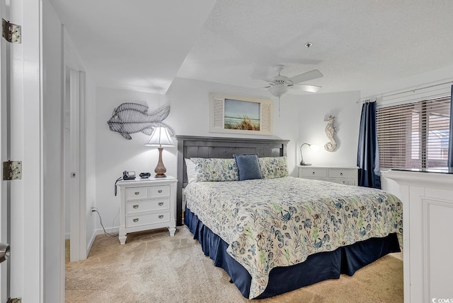 carpeted bedroom with ceiling fan and a textured ceiling