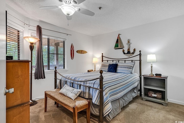 carpeted bedroom with ceiling fan and a textured ceiling