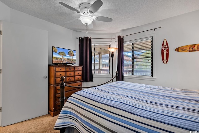 carpeted bedroom with ceiling fan and a textured ceiling