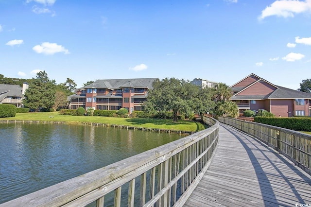 view of dock featuring a water view and a lawn