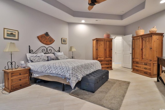 bedroom featuring a raised ceiling and ceiling fan