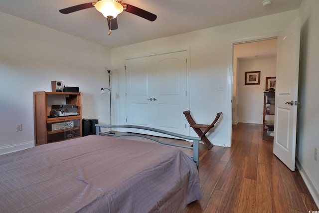 bedroom with a closet, dark hardwood / wood-style floors, and ceiling fan