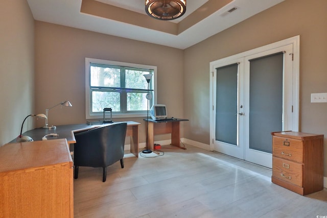 home office featuring french doors and a raised ceiling