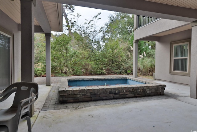 view of swimming pool with a hot tub and a patio