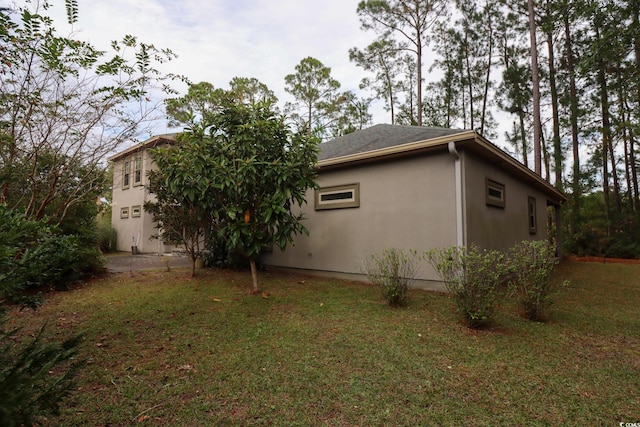 view of side of home with a lawn