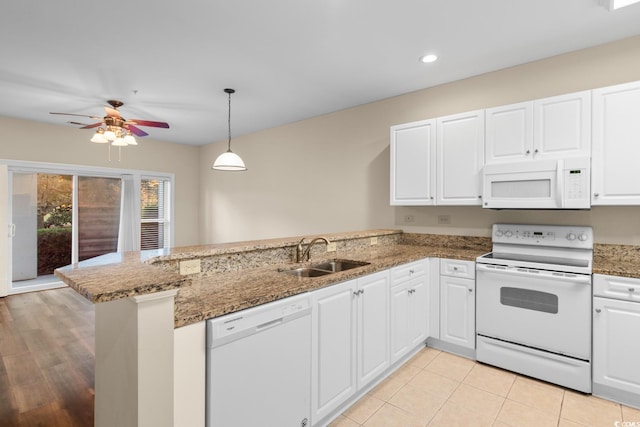 kitchen with white cabinets, white appliances, sink, and kitchen peninsula