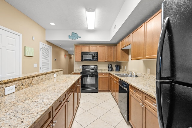 kitchen featuring black appliances, sink, light stone counters, and light tile patterned flooring