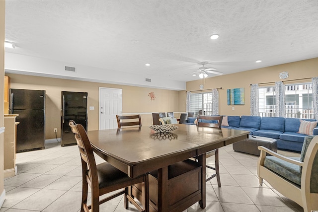 dining space featuring a textured ceiling, light tile patterned floors, and ceiling fan