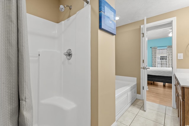 bathroom with ceiling fan, a textured ceiling, vanity, plus walk in shower, and tile patterned floors