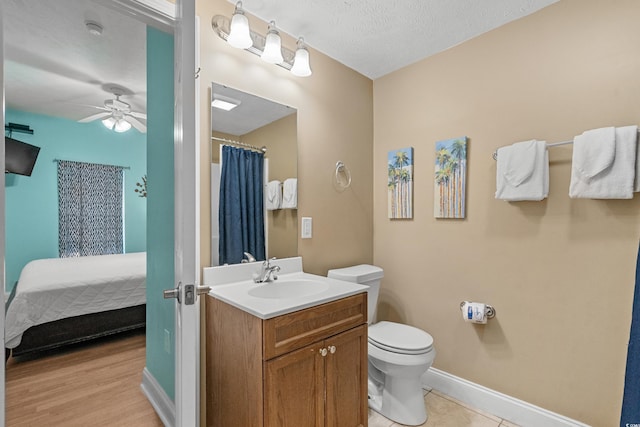 bathroom featuring ceiling fan, a textured ceiling, hardwood / wood-style floors, vanity, and toilet