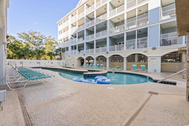 view of pool featuring a hot tub and a patio area